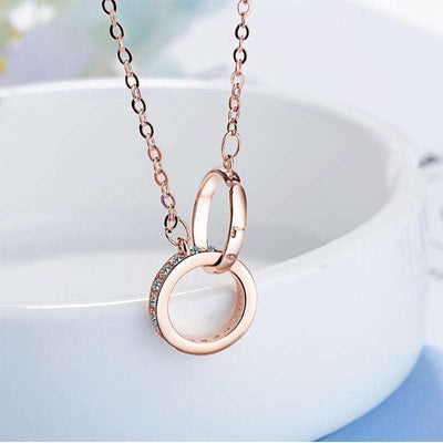 Rose gold double ring necklace with cubic zirconia and geometric design on chain